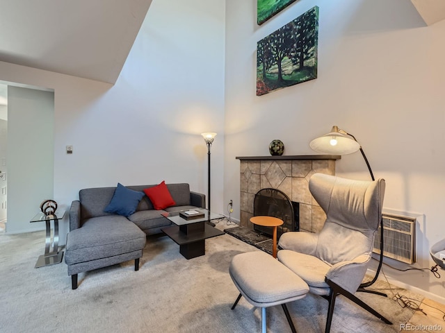 carpeted living room with a tile fireplace