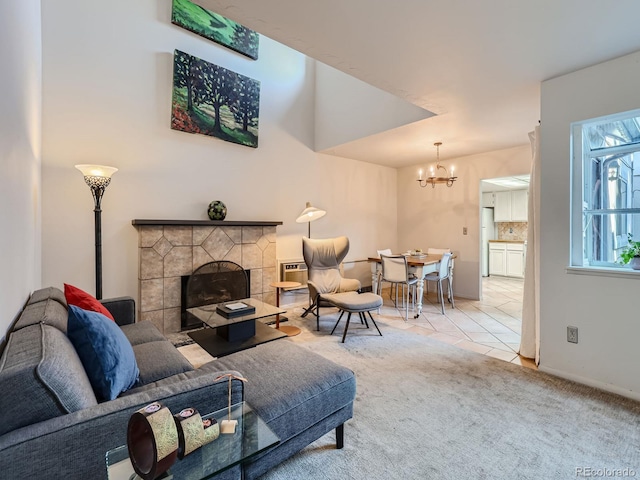 carpeted living room with a tile fireplace and an inviting chandelier