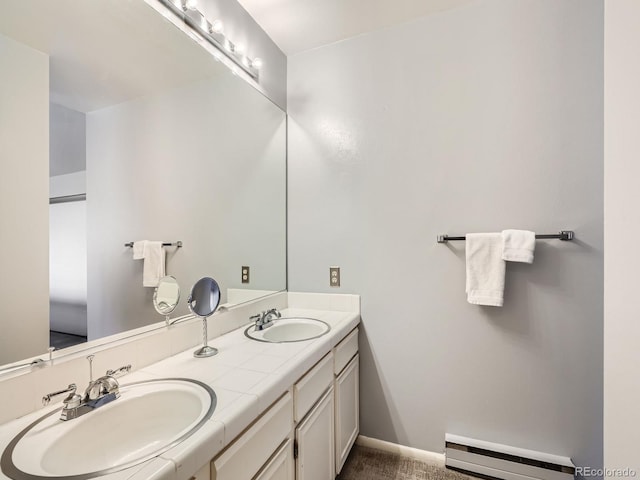 bathroom with baseboard heating and dual bowl vanity