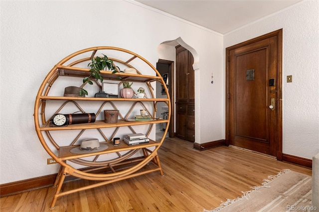 hallway with hardwood / wood-style flooring and crown molding