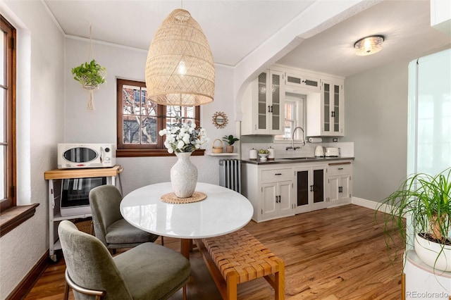 dining room featuring ornamental molding, dark hardwood / wood-style floors, and sink