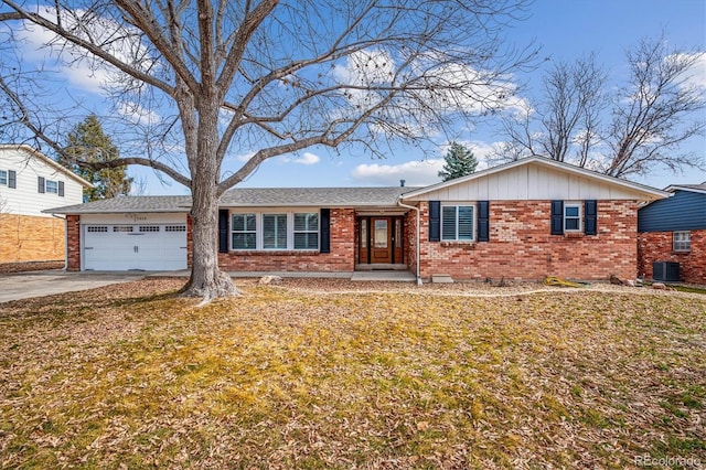 view of front of home with a garage, a front lawn, and central air condition unit