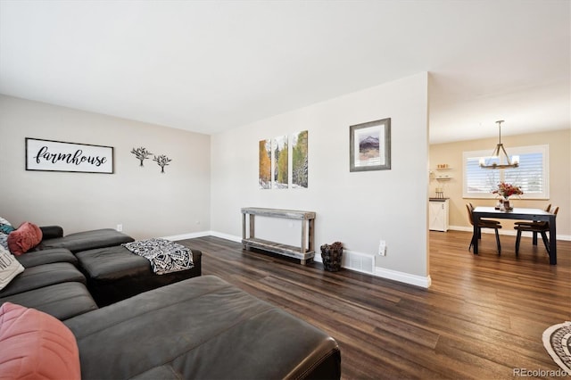 living room with a notable chandelier and dark hardwood / wood-style flooring