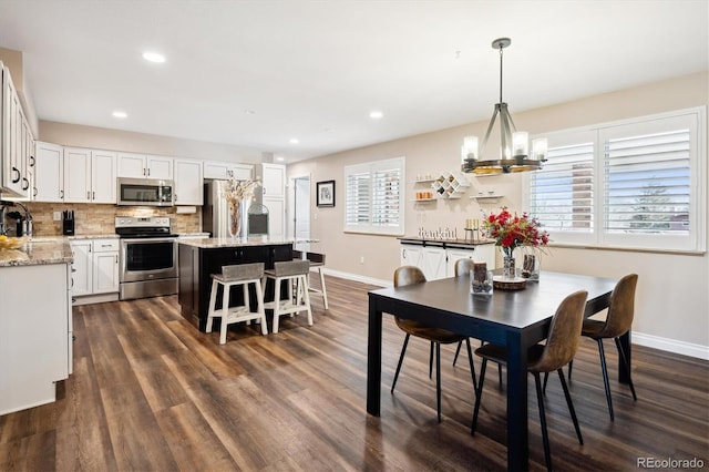 dining room featuring sink, a chandelier, and dark hardwood / wood-style flooring