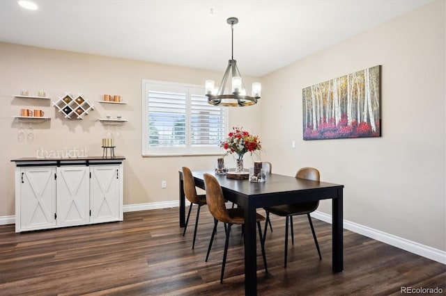 dining room with dark hardwood / wood-style flooring and a chandelier