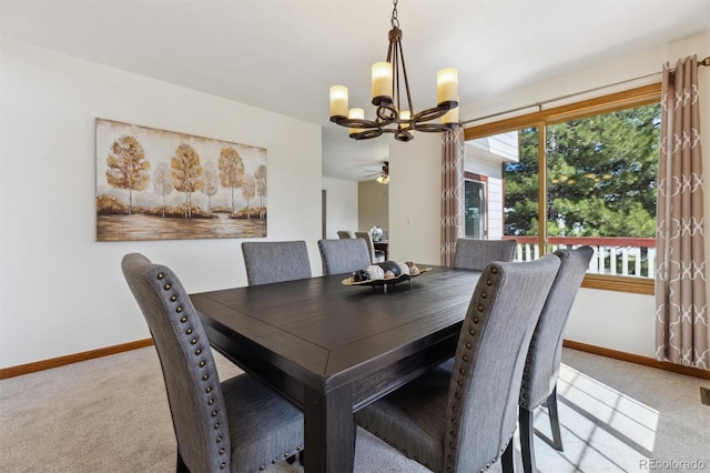 carpeted dining space featuring a notable chandelier and baseboards