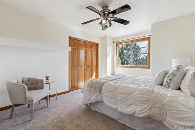 bedroom featuring a ceiling fan, light colored carpet, baseboards, and a closet