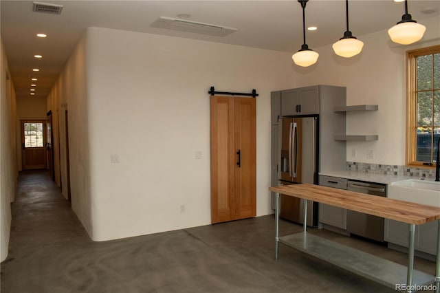 kitchen featuring a barn door, wood counters, visible vents, finished concrete flooring, and appliances with stainless steel finishes