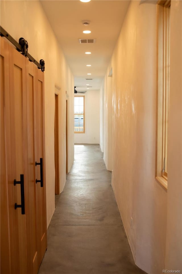 hallway with a barn door and visible vents