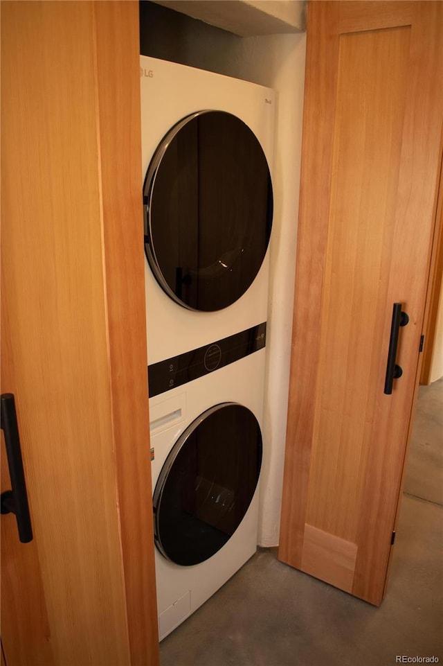 washroom with stacked washer and dryer and laundry area