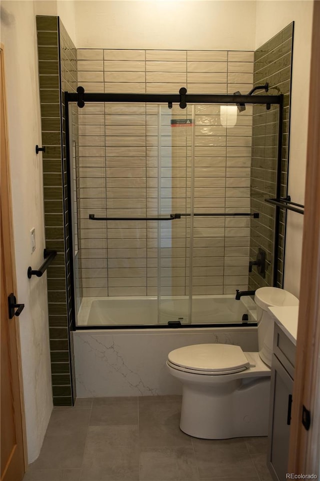 full bathroom featuring tile patterned flooring, shower / bath combination with glass door, vanity, and toilet