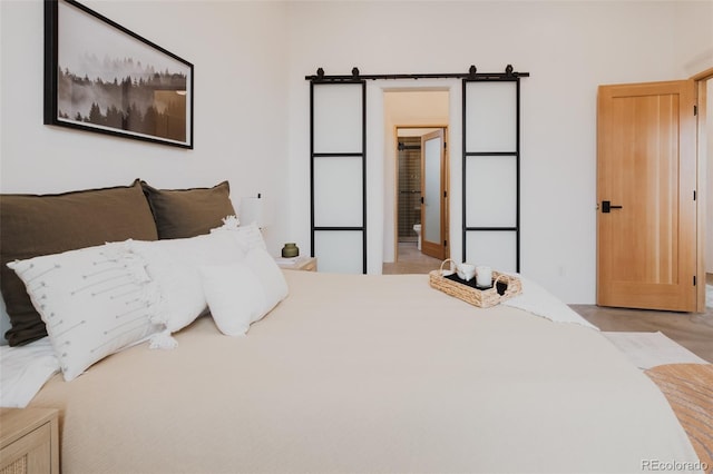 bedroom with ensuite bath and a barn door