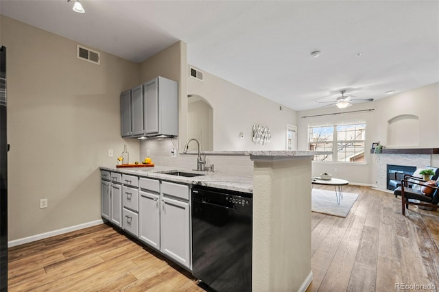 kitchen with ceiling fan, sink, black dishwasher, light hardwood / wood-style flooring, and kitchen peninsula