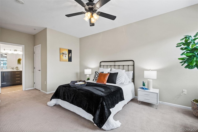 carpeted bedroom with ensuite bathroom and ceiling fan