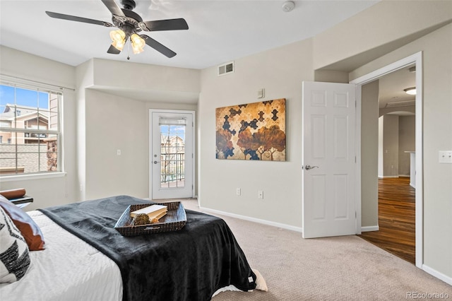 carpeted bedroom with access to exterior, multiple windows, and ceiling fan