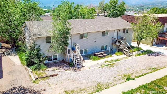 1025 Magnolia St, Colorado Springs, CO 80907 - rear view of property featuring stairway and roof with shingles