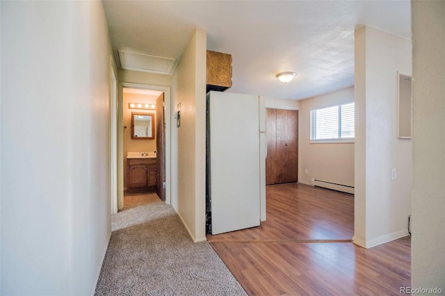 1025 Magnolia St, Colorado Springs, CO 80907 - corridor featuring a baseboard heating unit, light wood finished floors, baseboards, and attic access