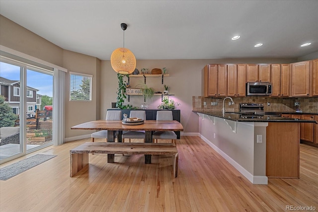 23831 Eagle Bend Ln, Parker, CO 80138 - kitchen featuring stainless steel appliances, baseboards, light wood finished floors, decorative backsplash, and recessed lighting