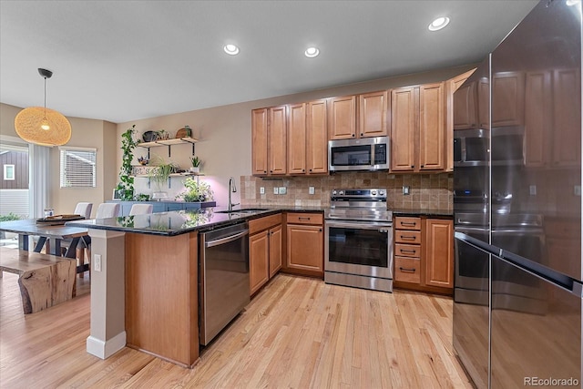 23831 Eagle Bend Ln, Parker, CO 80138 - kitchen featuring stainless steel appliances, a sink, a peninsula, light wood-style floors, and open shelves