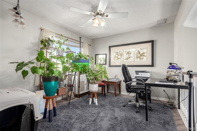 office space with heating unit, ceiling fan, dark hardwood / wood-style floors, and a textured ceiling