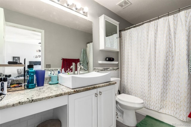 bathroom featuring vanity, toilet, and walk in shower