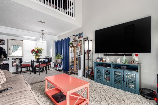 carpeted living room featuring a towering ceiling and a textured ceiling