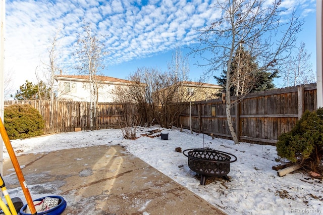 snow covered patio featuring an outdoor fire pit