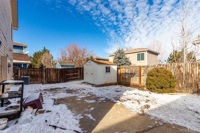 yard covered in snow featuring a storage unit and cooling unit