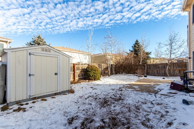 yard covered in snow featuring a shed