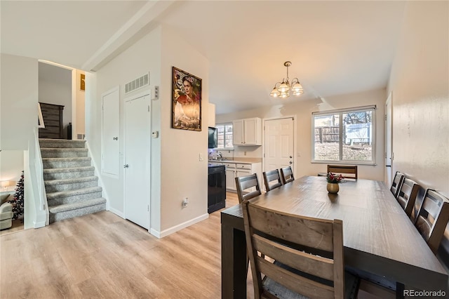 dining area featuring a chandelier, light hardwood / wood-style flooring, and sink