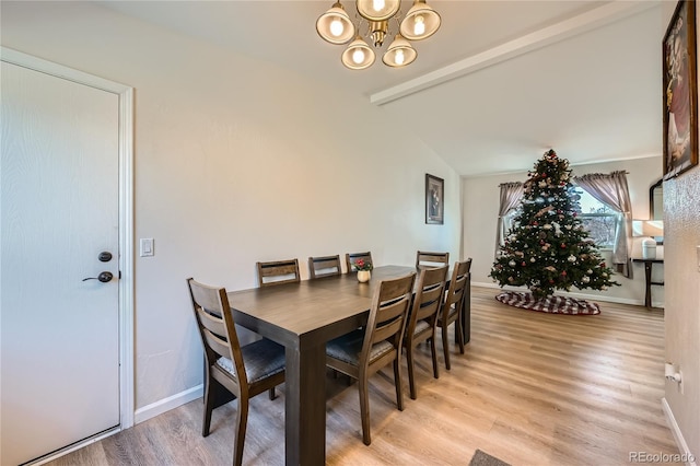 dining room with a notable chandelier, lofted ceiling with beams, and light hardwood / wood-style floors