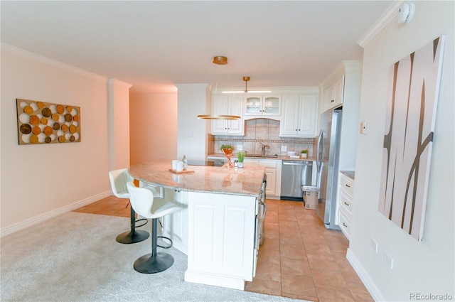 1020 15th St Unit 29L, Denver, CO 80202 - kitchen with stainless steel appliances, white cabinets, a kitchen breakfast bar, backsplash, and light stone counters
