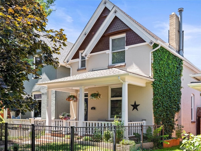 437 S Grant St, Denver, CO 80209 - view of front of home featuring covered porch, a chimney, brick siding, and a fenced front yard