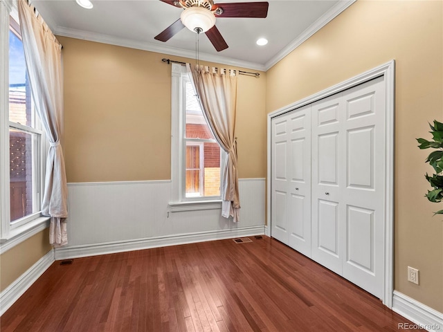 437 S Grant St, Denver, CO 80209 - unfurnished bedroom featuring wainscoting, wood finished floors, crown molding, a closet, and a ceiling fan