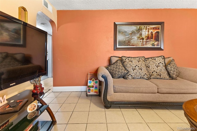 living room featuring baseboards, visible vents, and tile patterned floors