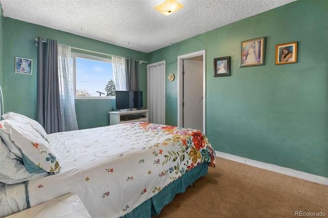 carpeted bedroom featuring baseboards and a textured ceiling