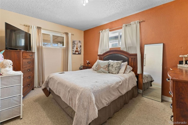 carpeted bedroom featuring a textured ceiling and a textured wall