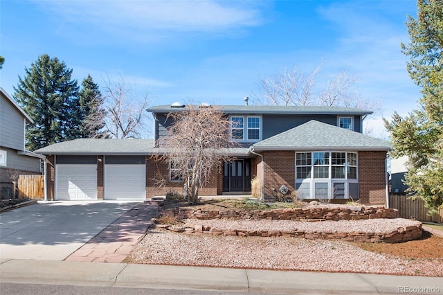 traditional-style home with brick siding, a shingled roof, concrete driveway, fence, and a garage