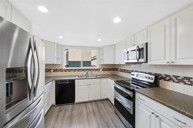 kitchen featuring dark countertops, appliances with stainless steel finishes, and open shelves