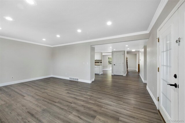 unfurnished living room featuring dark wood-style flooring, recessed lighting, visible vents, ornamental molding, and baseboards