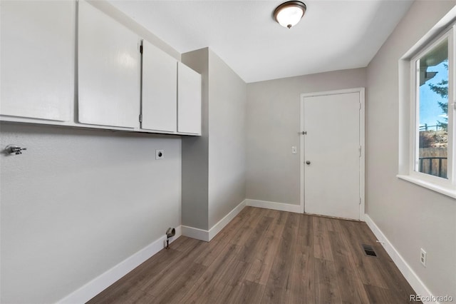 washroom with visible vents, cabinet space, electric dryer hookup, wood finished floors, and baseboards