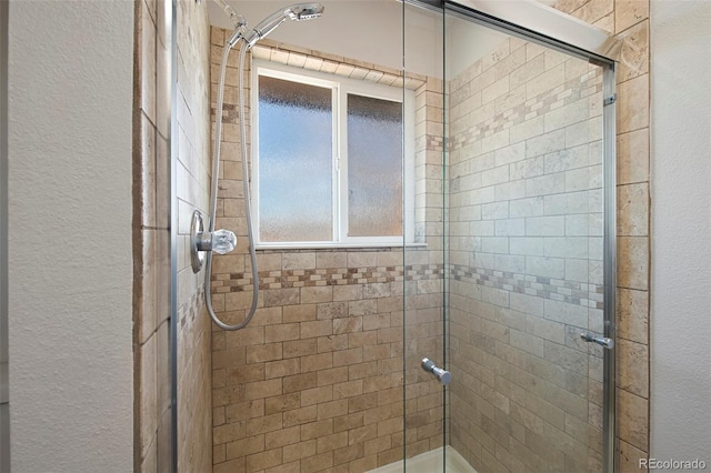 bathroom with a textured wall and a shower stall