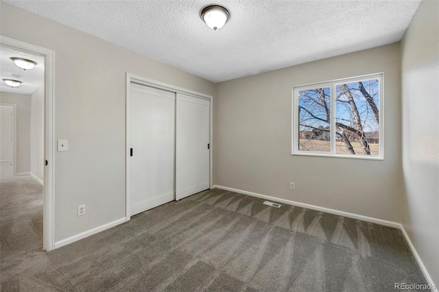 unfurnished bedroom with a closet, carpet flooring, visible vents, and baseboards