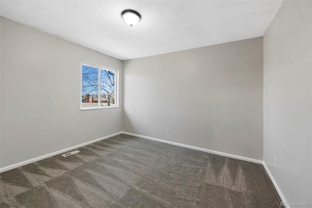 spare room featuring baseboards, a textured ceiling, visible vents, and carpet flooring