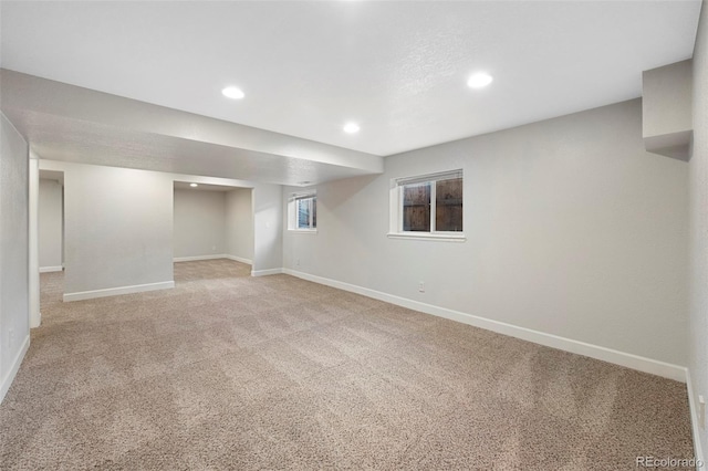 basement featuring recessed lighting, baseboards, and light colored carpet