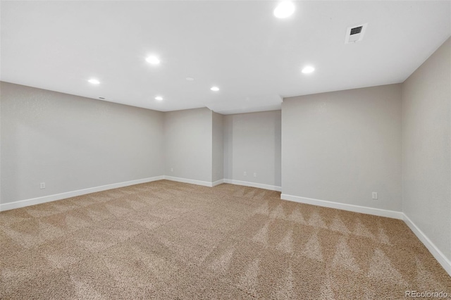 empty room featuring light carpet, baseboards, and recessed lighting