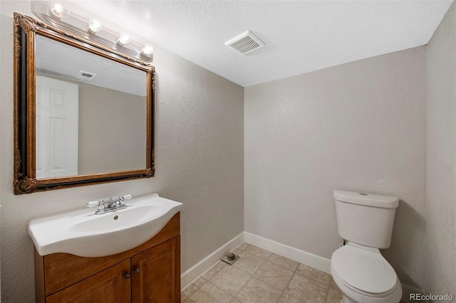 half bath with toilet, baseboards, visible vents, and vanity