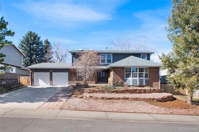 traditional-style house featuring a shingled roof, concrete driveway, an attached garage, fence, and brick siding