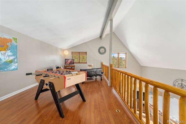 recreation room featuring lofted ceiling with beams, wood finished floors, and baseboards