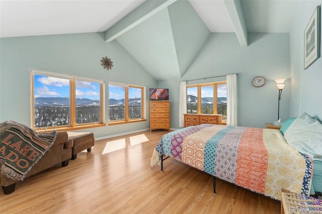 bedroom featuring beamed ceiling, wood finished floors, and high vaulted ceiling